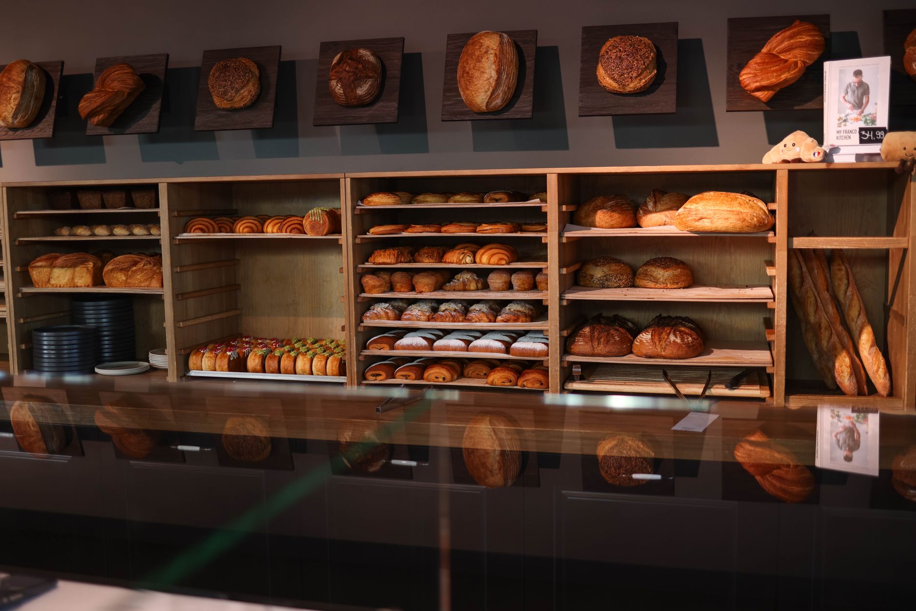 A cozy bakery showcasing an array of freshly baked bread and pastries on wooden shelves.