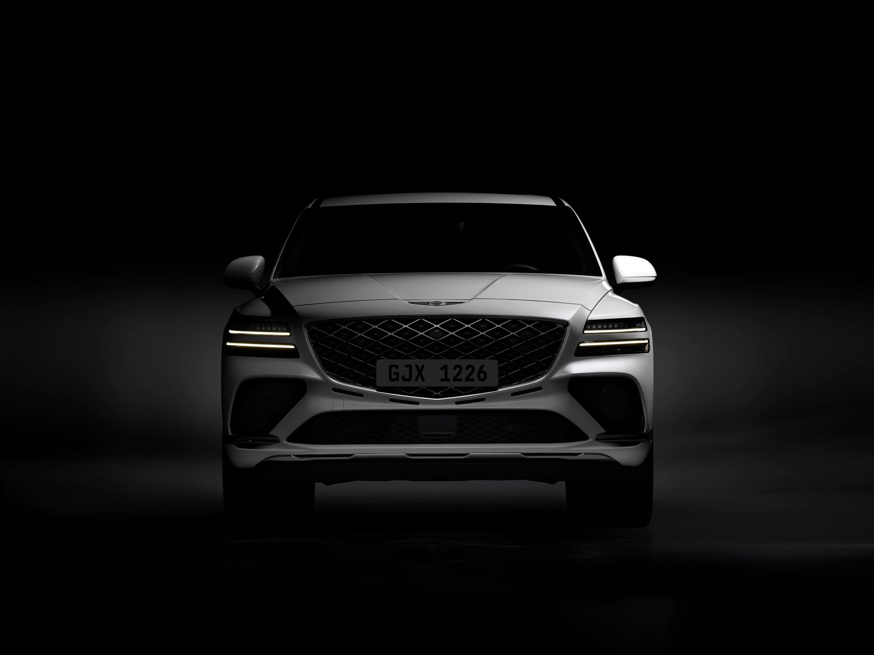 Front view of a luxury Genesis GV80 Coupe in a studio setting.