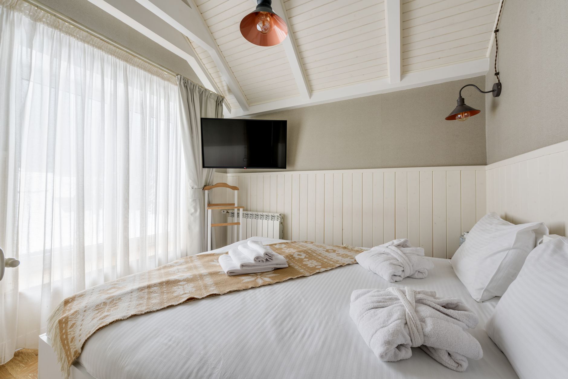 Bright minimalist bedroom with soft lighting, white decor, and a modern aesthetic.